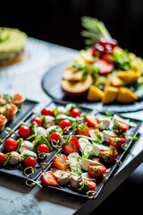 Tasty skewers of fresh tomatoes, strawberries, and cheese await at a joyful outdoor event