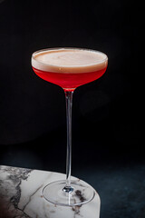 A vibrant red cocktail awaits in a tall glass, ready to be savored
