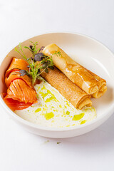Savory crepes paired with smoked salmon and drizzled with creamy sauce create a delightful meal