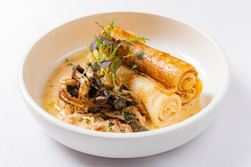 Warm crepes filled with tender chicken and earthy mushrooms, drizzled with a rich cream sauce
