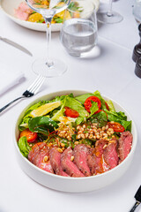 A delicious salad with tender beef and fresh veggies awaits at a stylish table