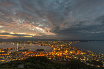 Fototapeta premium Dramatic sunset clouds and golden light illuminating the iconic cityscape of Hakodate, Hokkaido, viewed from Mount Hakodate.