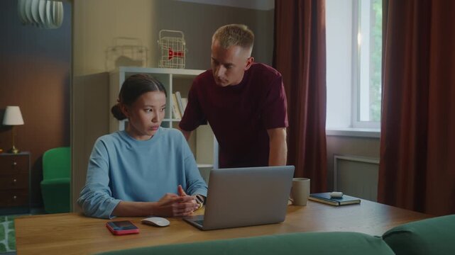 Boss man checks scold asian woman subordinate do task incorrectly mistake fail report. Management dissatisfied work. Employee wrong answer, bug fixes, error correction. Bad job. Guy show laptop screen