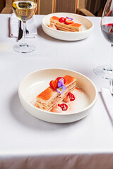 Sweet layers of cake topped with strawberries and edible flowers attract attention at dinner