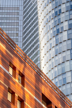 Skyscraper architecture reflects alongside residential and offices as contrast strengthens the urban facade, presenting a mixed use setting characteristic of Paris and its La Defense district