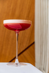 A vibrant red cocktail glass shines on a table, enhancing the inviting ambiance