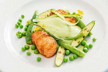 Delicious salmon fillets paired with vibrant green peas, asparagus, and a creamy sauce
