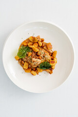 Delightful bowl of gnocchi with salmon, herbs, and spices offers a cozy culinary experience