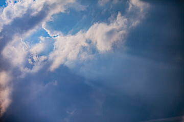 Soft clouds float in a tranquil sky as sunlight breaks through, creating a peaceful scene