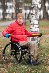 a man in a wheelchair with a rubber expander in his hands