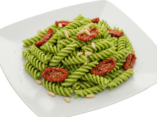 Green fusilli pasta with pesto and sun-dried tomatoes isolated on transparent background, delicious...