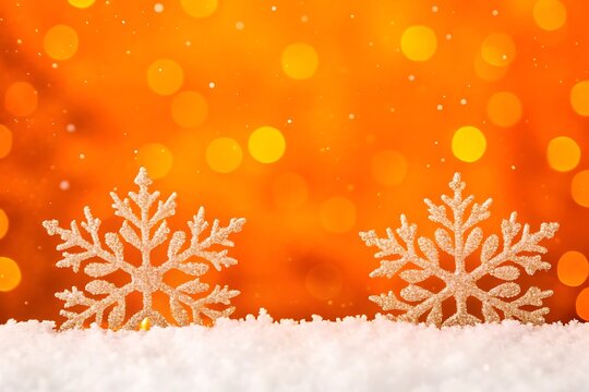 Two glittering snowflakes resting on white snow with blurry orange bokeh lights