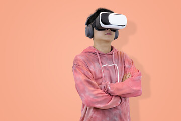 Excited young Asian man wear hoodie reacting with joy while wearing a virtual reality headset, symbolizing the thrilling first experience in studio background