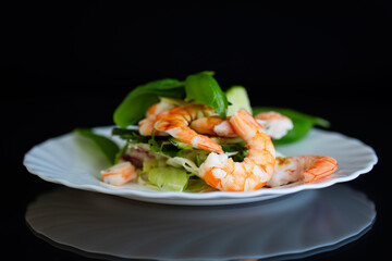 Light salad with seafood on a black background