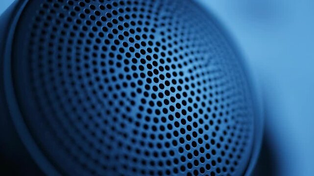 Close-up of a speaker grill with small holes in a spherical shape.