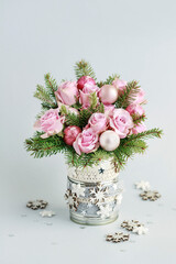 Modern Christmas pink decoration with roses, fir and baubles. Postcard motif.