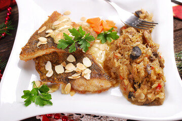 Carp fillets fried with almond flakes and sauerkraut with mushrooms for Christmas