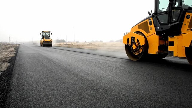 Road rollers smoothing new asphalt on a construction site road