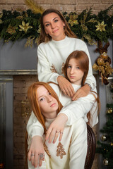A family portrait featuring a mother and her two daughters with long red hair