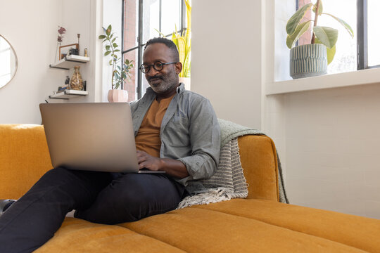 Confident Man Working on Laptop Surrounded by Plants