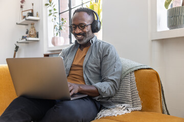 Man Listening to Music on Laptop with Headphones
