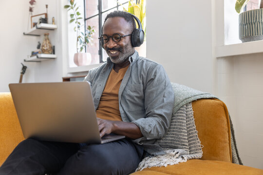 Man Listening to Music on Laptop with Headphones