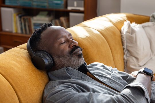 Man Resting with Headphones in Cozy Living Space