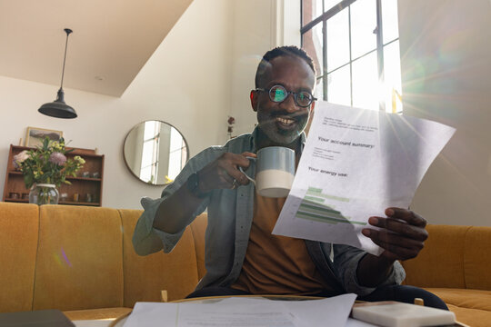 Happy man sips coffee enjoying his account summary for fuel and power usage
