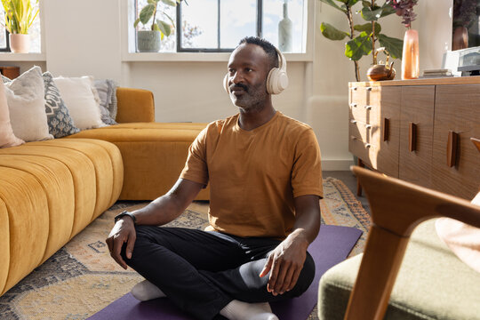 Man meditates on yoga mat at home relaxation - Powered by Adobe