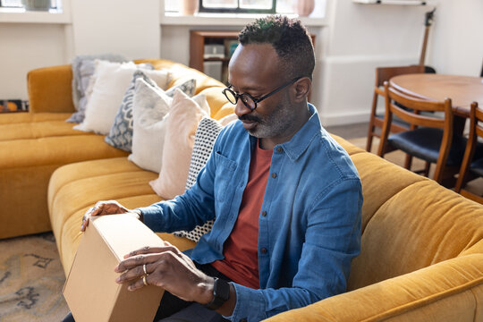 Smiling man about to open online order at home