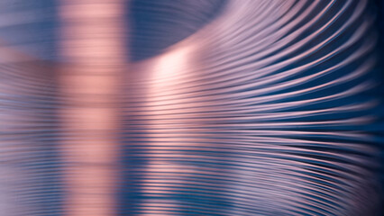 Abstract industrial metal background with blurred curved lines on blue. Shiny steel spiral spring texture with pink copper reflection for hardware manufacturing presentation. Photo