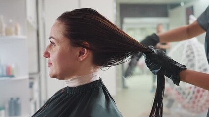 professional using paddle brush carefully, hairdresser gently detangles conditioned locks during styling session, stylist employs paddle brush to gently manage wet hair with controlled technique