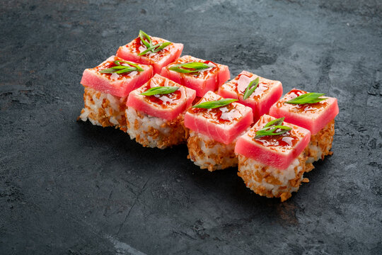 Fresh tuna sushi roll drizzled with teriyaki sauce and green onions from crispy rice. Gourmet Japanese maki, premium tuna roll, luxury seafood sushi with hashi