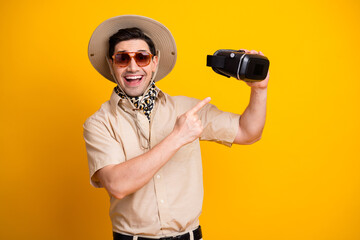 Man in safari style outfit with hat scarf wearing sunglass and virtual reality headset ready for...