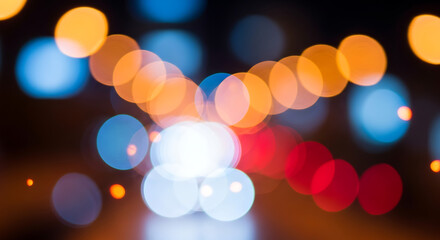 Colorful abstract bokeh background showing defocused headlights and street illumination at night time.