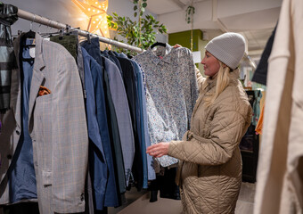 woman browsing clothes in secondhand shop 