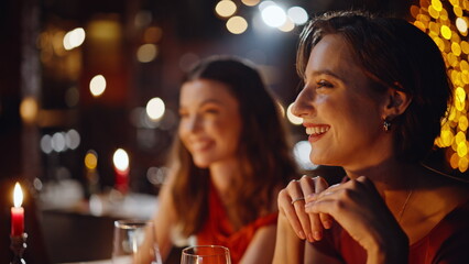 Carefree girls flirting guys at romantic couples date in dark pub closeup. 