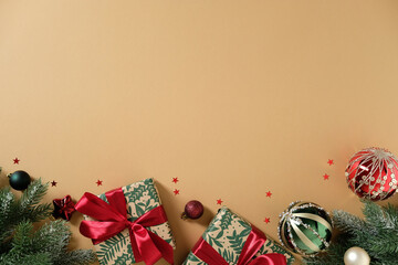 Christmas gifts and decorations festive bottom border on a beige background.