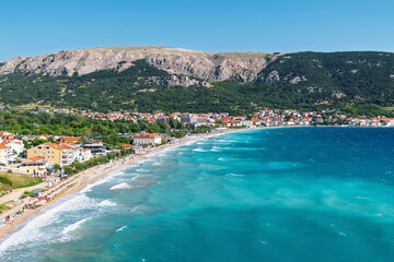 Scenic coastal town with vibrant blue sea and mountains in the background. Ba&scaron;ka, Krk island, Croatia
