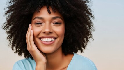 Joyful young Black woman with stunning curly hair smiles brightly, her radiant confidence and healthy skin reflecting authentic happiness and wellness