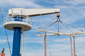 Industrial dock crane against blue sky used for large cargo transfers