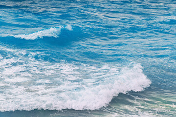 Vibrant ocean waves crashing against the shore on a sunny day