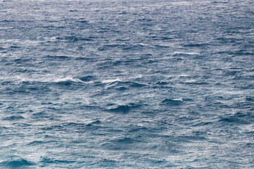 Vast ocean waves under cloudy sky with choppy waters