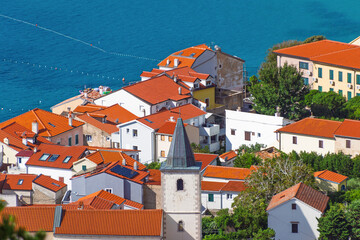 Scenic coastal village with red-tiled roofs overlooking blue sea. Ba&scaron;ka, Krk island, Croatia