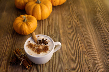 Autumn Pumpkin Spice Latte. A cozy autumn scene with a spiced latte, pumpkins, and cinnamon sticks