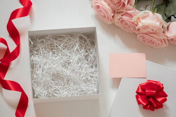 White square gift box with open lid and filler inside, blank for your product, top view, birthday, women's day, valentine's day background