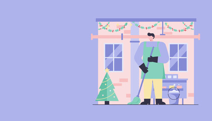 Worker sweeping outside building decorated for Christmas holidays