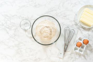 Baking tools and flour with eggs and whisk