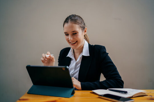 Cheerful woman using stylus on digital tablet, laughing during remote work session, showcasing creative ease, freelance flexibility and emotional connection with digital tools - Powered by Adobe