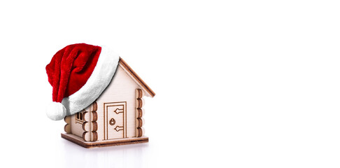 Santa Claus Hat on Wooden model of house on white background.. Christmas celebration